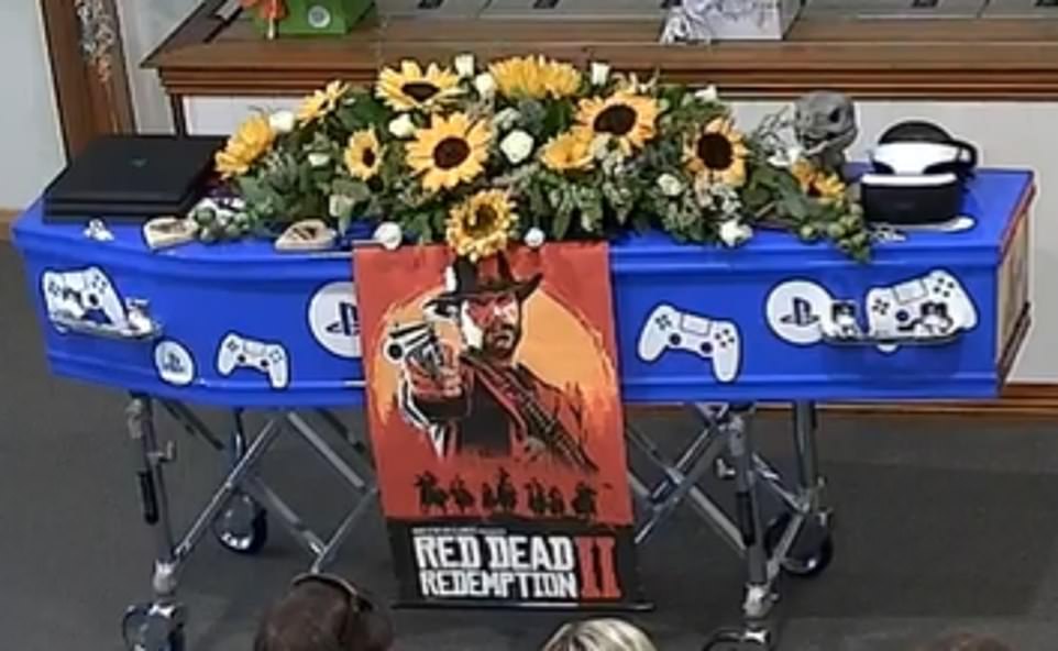 Zapalony gracz, jego mała niebieska trumna została ozdobiona sprzętem PlayStation i plakatem z jego ulubionej gry wideo