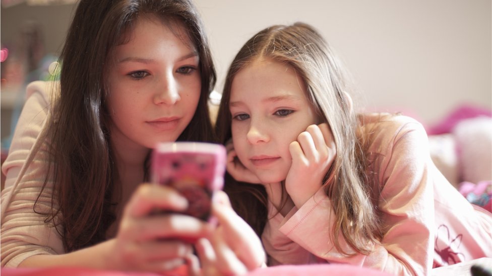 Nastolatki patrzące na telefon komórkowy