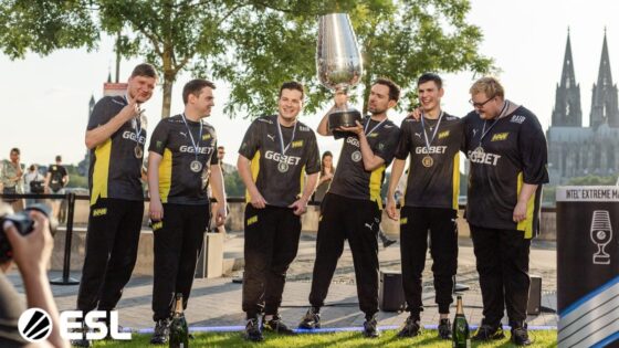 Drużyna Natus Vincere CS:GO pozuje razem na zewnątrz z dużym trofeum po wygranej imprezie.