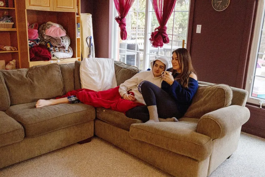 Frances Shawera siedzi z synem Matthew, który w poniedziałek wrócił do domu z gorączką.  Liczba uczniów nieobecnych w szkole z powodu choroby w całej GTA tej jesieni wzrosła w związku z potrójnym zagrożeniem COVID, RSV i grypą.