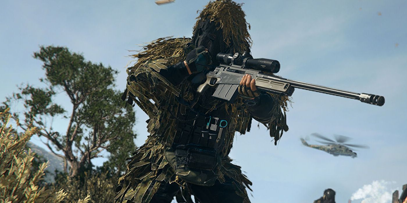 Gracz Warzone 2 ubrany w strój ghillie i pociągający za zamek w karabinie snajperskim.