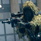 Warzone 2 character with Intervention sniper rifle and ghillie suit