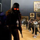People look at Counter-Strike art in the Louvre.