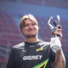 S1mple nie bierze udziału w CS2, ale niedługo będziesz mógł brać lekcje od niego S1mple, a Counter-Strike player, wearing a NAVI jersey and lifting a trophy in a stadium.